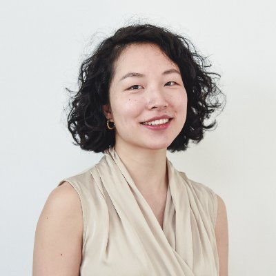 Journalist Yuan Yang, wearing a beige top, smiles directly at the camera against a white background.